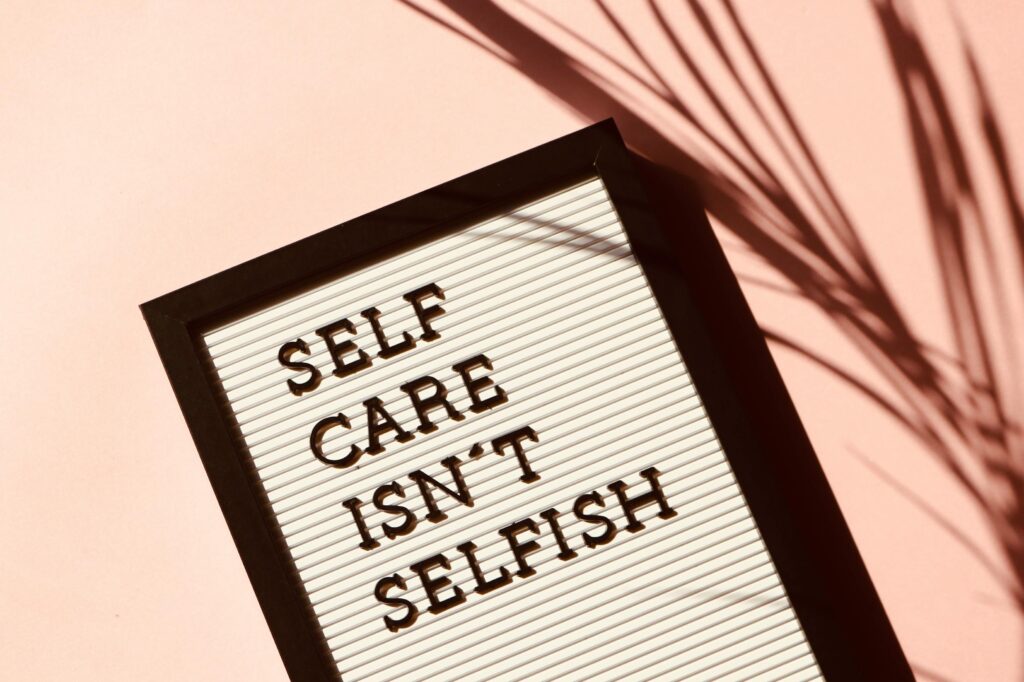 pexels-photo-2821823-2821823-1 Letter board displaying 'Self Care Isn't Selfish' with artistic shadow on pink background.